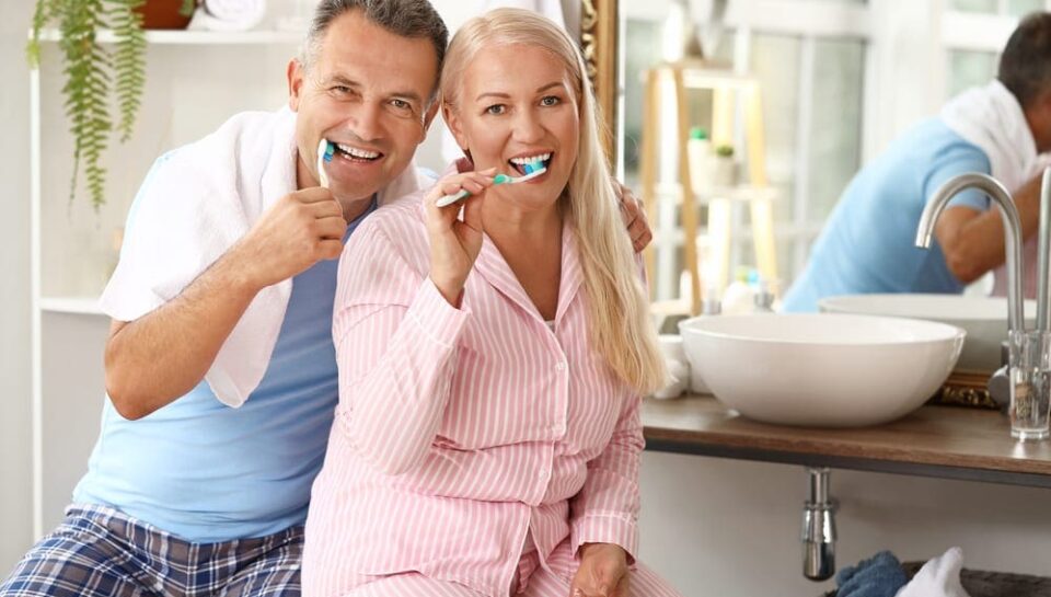 Mature couple brushing teeth at home